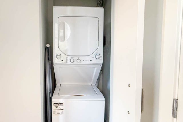 Compact laundry area with stacked washer and dryer, perfect for small spaces. - 221 - 55 E. Cordova, Vancouver Downtown