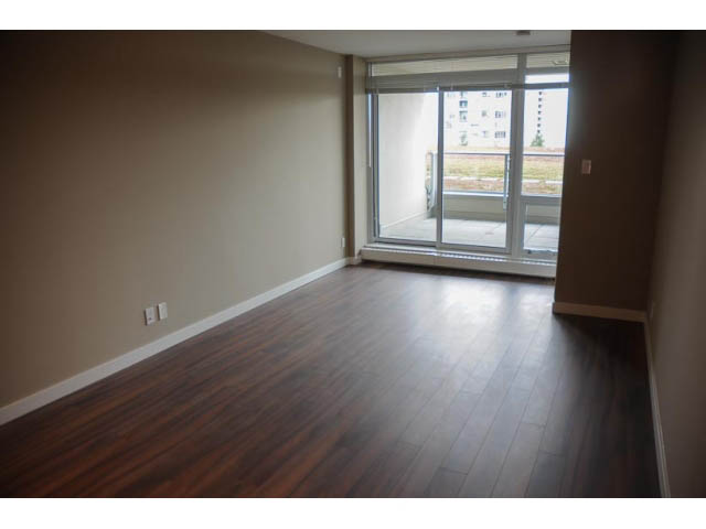 Furnished den with hardwood floors and sliding glass door leading to balcony. - 310 - 135 East 17th Street, North Vancouver