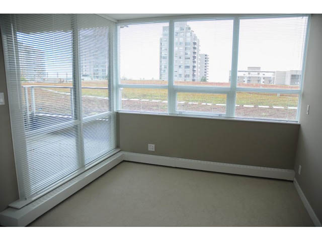 Bright den with large windows and city view, neutral walls and carpeted floor. - 310 - 135 East 17th Street, North Vancouver
