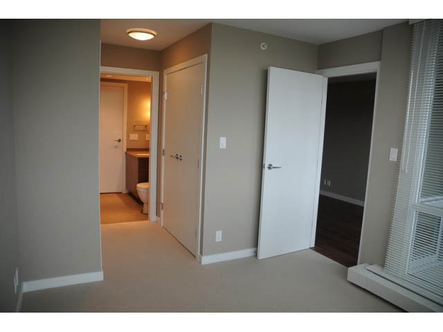 Spacious living room with hardwood floors and a view of the city. - 310 - 135 East 17th Street, North Vancouver