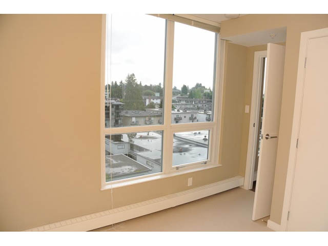 Bright living room with large windows offering a city view. - 707-135 East 17th Street, North Vancouver