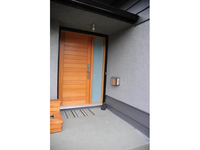 Furnished entryway with wooden door and bench, clean concrete floor. - 1362 East 20th St, North Vancouver