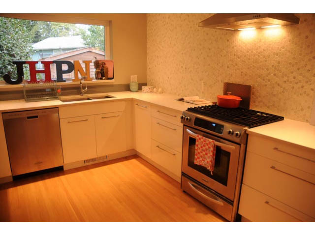 Bright kitchen with light wood cabinets, stainless steel appliances, and hardwood floors. - 1362 East 20th St, North Vancouver