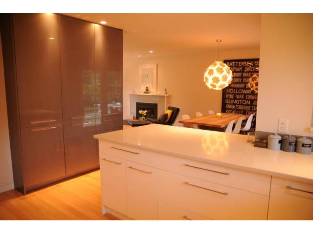 Bright kitchen with white countertops and dark cabinets, hardwood floors. - 1362 East 20th St, North Vancouver