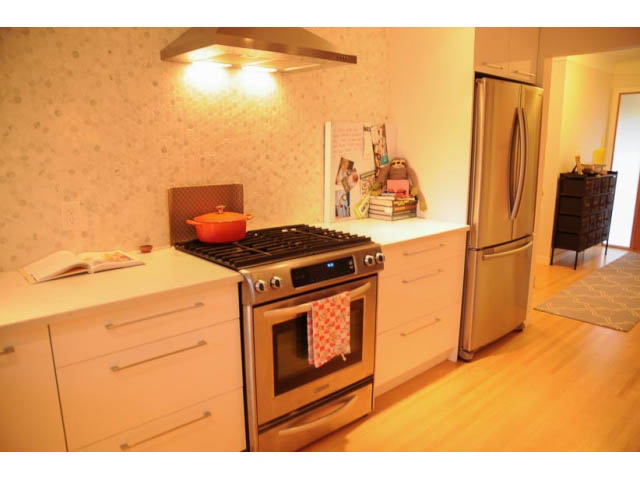 Bright kitchen with white countertops, stainless steel appliances, and hardwood floors. - 1362 East 20th St, North Vancouver