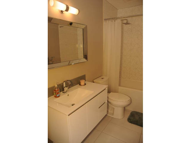 Bathroom with white vanity, shower curtain, and toilet. - 1362 East 20th St, North Vancouver