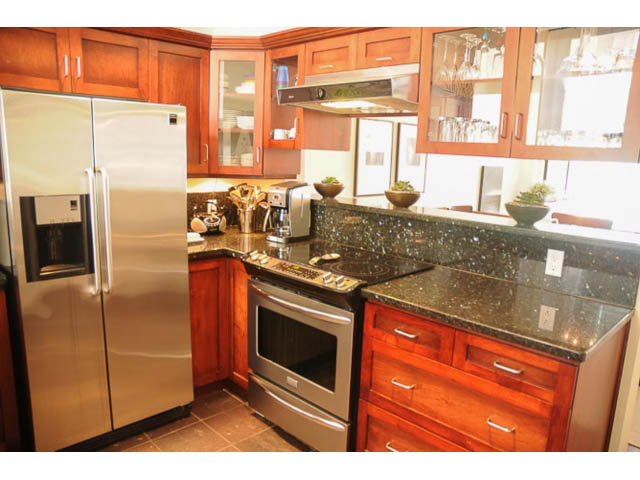 Bright kitchen with granite countertops, stainless steel appliances, and wooden cabinets. - 121 -1228 Marinaside Crescent, Vancouver Downtown