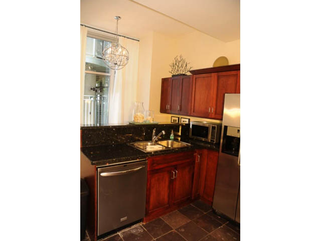 Bright kitchen with dark granite countertops, stainless steel appliances, and a view of the city. - 121 -1228 Marinaside Crescent, Vancouver Downtown