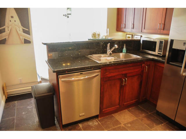 Bright kitchen with dark granite countertops, stainless steel appliances, and wooden cabinets. - 121 -1228 Marinaside Crescent, Vancouver Downtown