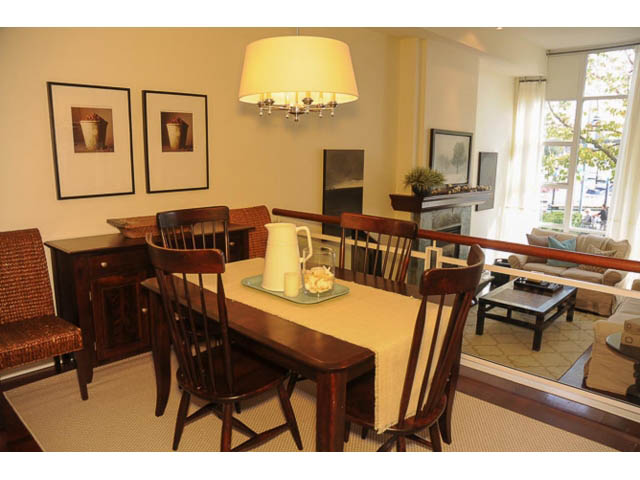 Furnished dining area with wooden table, chairs, and city view. - 121 -1228 Marinaside Crescent, Vancouver Downtown