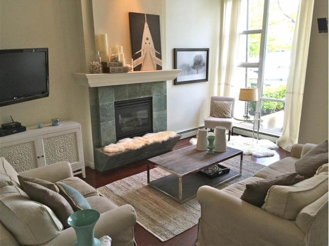 Spacious living room with fireplace, modern decor, and large windows. - 121 -1228 Marinaside Crescent, Vancouver Downtown