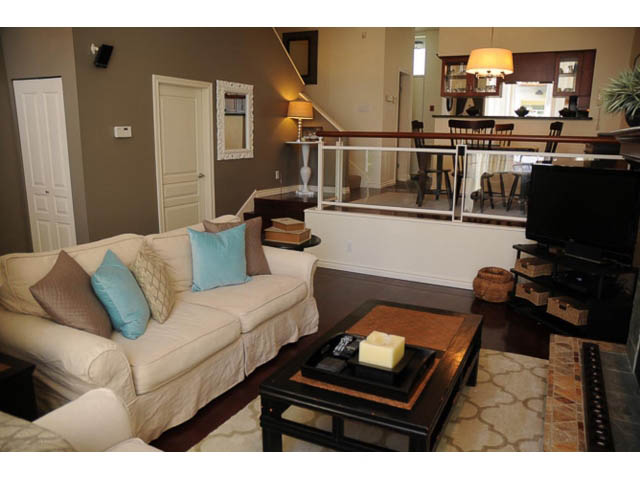 Furnished living room with a cozy sofa, glass railing, and dining area in the background. - 121 -1228 Marinaside Crescent, Vancouver Downtown