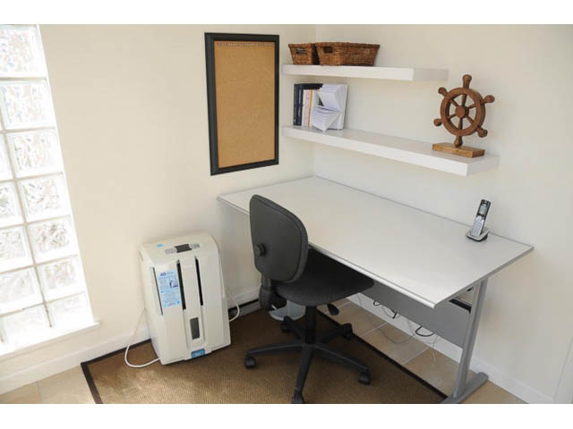 Bright home office with floating shelves, cork board, and nautical decor. - 121 -1228 Marinaside Crescent, Vancouver Downtown