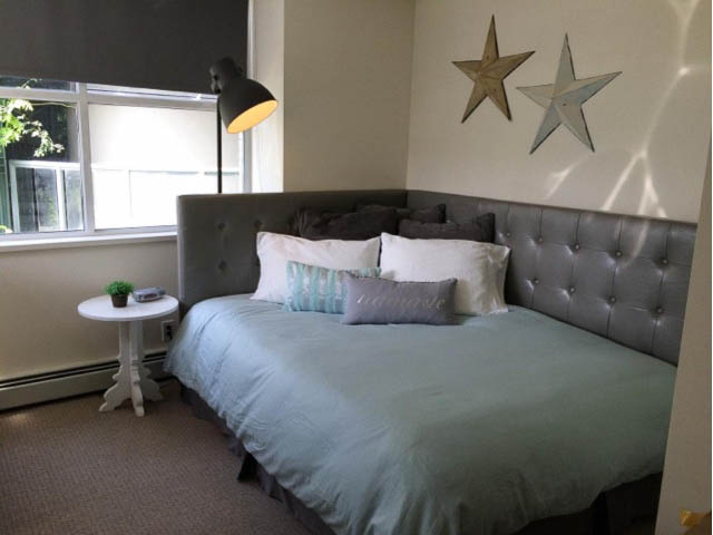 Bright bedroom with tufted headboard, star wall decor, and natural light from window. - 121 -1228 Marinaside Crescent, Vancouver Downtown