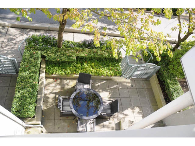 Furnished patio with greenery, table, and chairs. - 121 -1228 Marinaside Crescent, Vancouver Downtown
