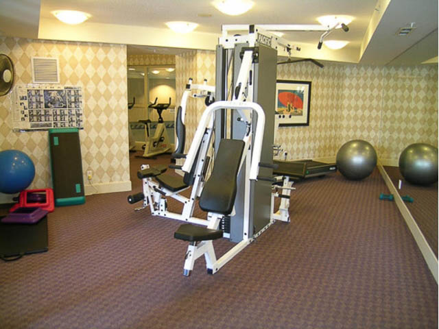 Fitness room with cardio equipment and weights, carpeted floor. - 121 -1228 Marinaside Crescent, Vancouver Downtown