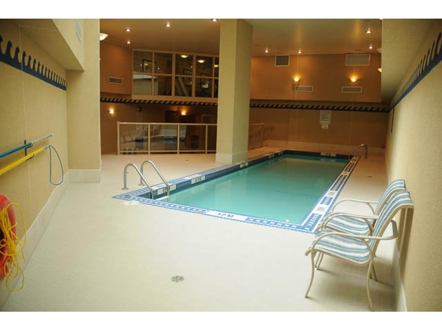 Furnished indoor pool area with striped chairs and lifeguard equipment. - 121 -1228 Marinaside Crescent, Vancouver Downtown
