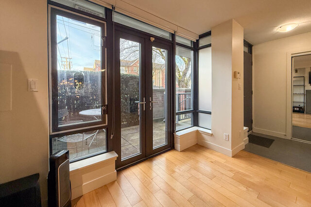 Spacious living room with hardwood floors and large windows, offering a view of the neighborhood. - 3238 Tupper Street, Vancouver West Side