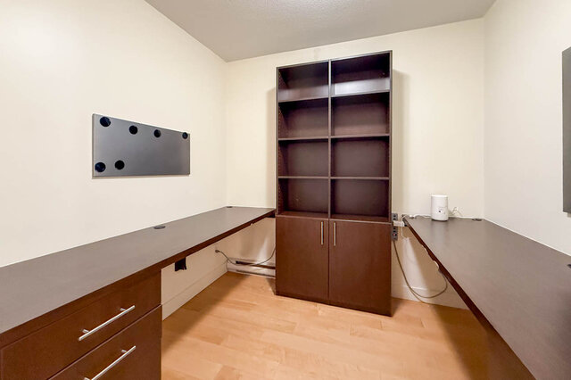 Modern den with built-in shelving, hardwood floors, and a sleek desk setup. - 3238 Tupper Street, Vancouver West Side