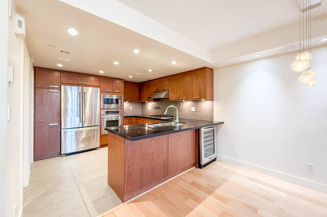 Modern kitchen with hardwood floors and stainless steel appliances. - 3238 Tupper Street, Vancouver West Side