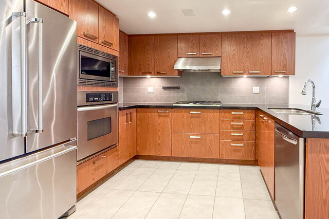 Modern kitchen with stainless steel appliances and wood cabinets. - 3238 Tupper Street, Vancouver West Side