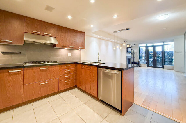 Modern kitchen with wooden cabinets, stainless steel appliances, and a city view. - 3238 Tupper Street, Vancouver West Side