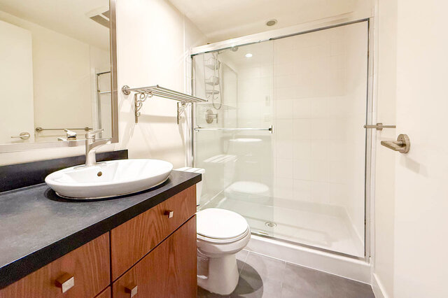 Spacious bathroom with modern sink, glass shower, and dark countertop. - 3238 Tupper Street, Vancouver West Side