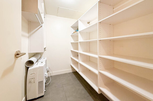 Spacious laundry room with white shelving and a compact air conditioner. - 3238 Tupper Street, Vancouver West Side