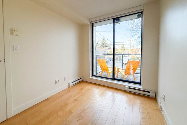 Spacious living room with hardwood floors, large sliding glass doors, and a city view. - 3238 Tupper Street, Vancouver West Side