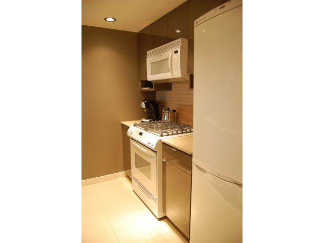 Bright kitchen with white appliances and light wood cabinets. - 911 - 939 Expo Boulevard, Vancouver Downtown