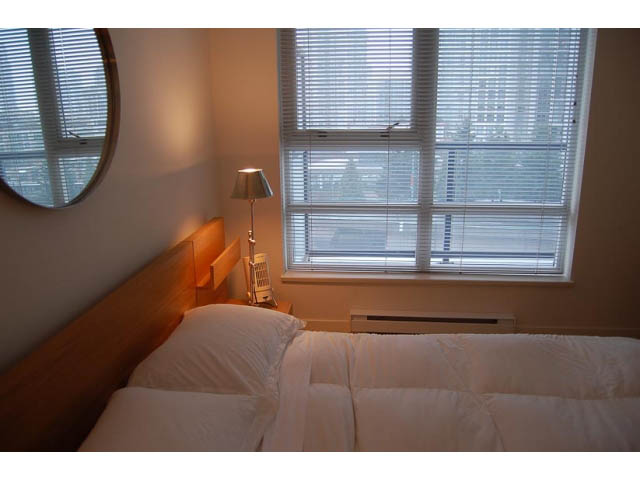 Furnished 1-bedroom + den with wooden headboard and blinds covering large windows. - 911 - 939 Expo Boulevard, Vancouver Downtown