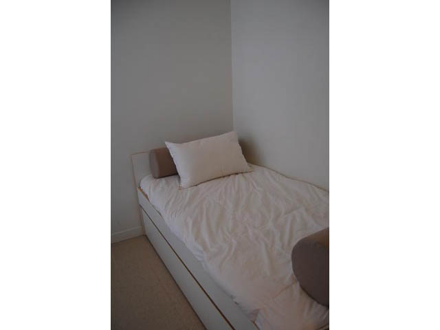 Furnished 1-bedroom + den with white bedding and wooden headboard. - 911 - 939 Expo Boulevard, Vancouver Downtown