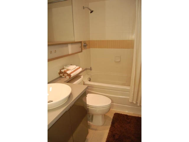 Furnished bathroom with white sink, toilet, and shower curtain. - 911 - 939 Expo Boulevard, Vancouver Downtown