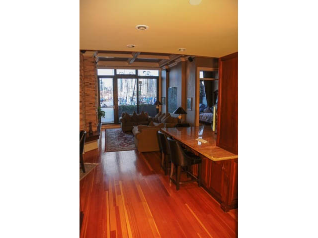 Spacious living room with hardwood floors, city view, and modern furnishings. - 654 Millbank, Vancouver West Side