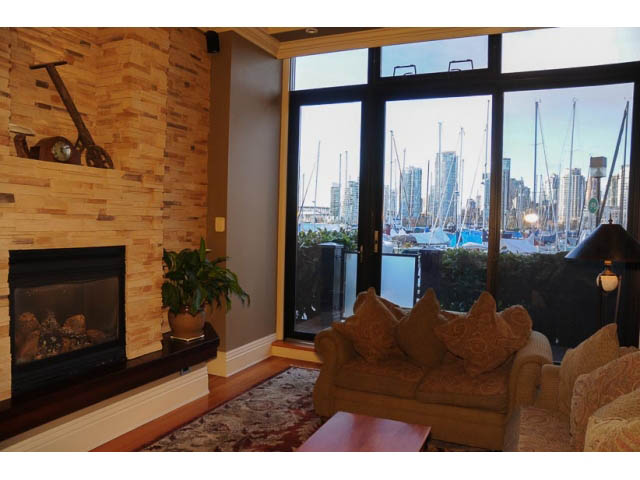 Spacious living room with a wood-burning fireplace, large windows offering a stunning city view. - 654 Millbank, Vancouver West Side