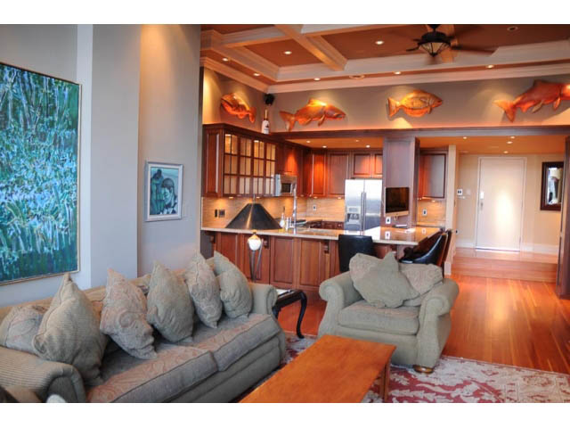 Furnished living room with hardwood floors, cozy couch, and kitchen counter in the background. - 654 Millbank, Vancouver West Side