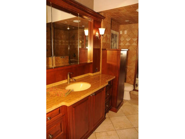 Furnished bathroom with wooden cabinets, granite countertops, and tiled walls. - 654 Millbank, Vancouver West Side