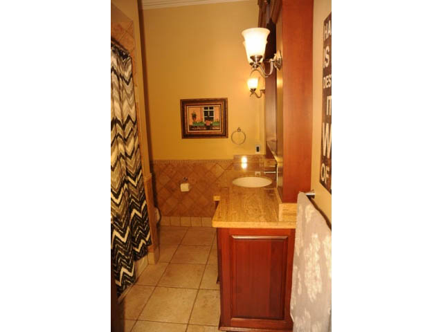 Bathroom with wooden vanity, tiled floor, and wall art. - 654 Millbank, Vancouver West Side