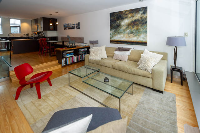 Furnished living room with hardwood floors, modern furniture, and a large abstract painting. - 834 W 7th Ave, Vancouver West Side