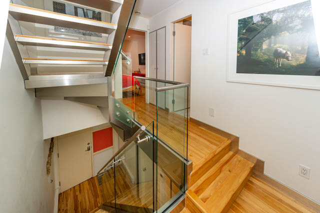 Bright staircase with glass railings and wooden flooring, leading to a den area. - 834 W 7th Ave, Vancouver West Side