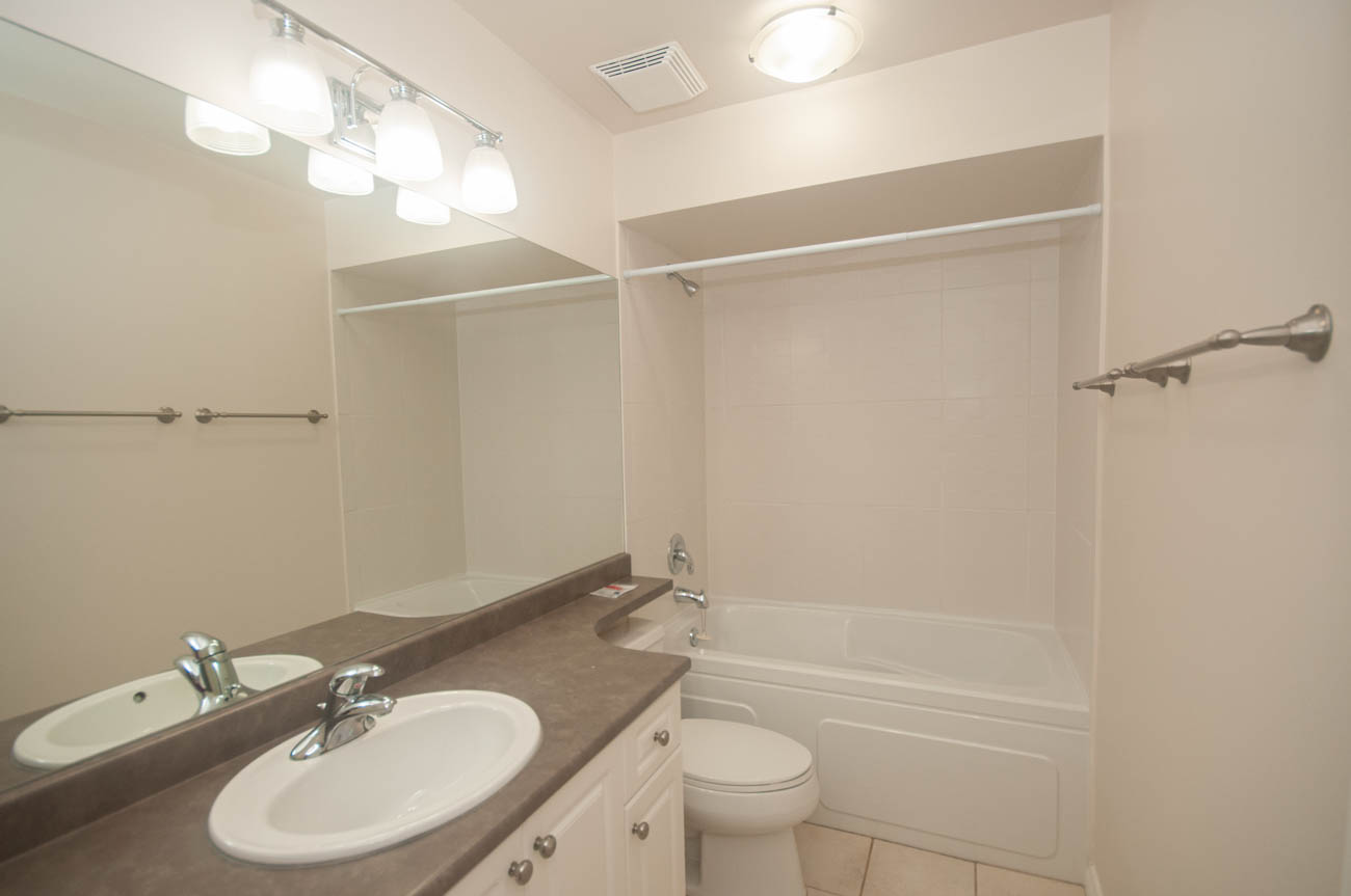 Spacious bathroom with dual sinks, large mirror, and walk-in shower. - 1059 Heritage Blvd, North Vancouver