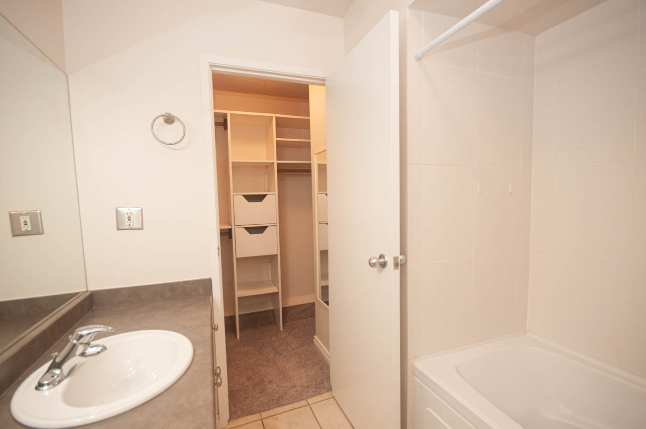 Spacious bathroom with a large vanity, walk-in closet, and corner bathtub. - 1059 Heritage Blvd, North Vancouver