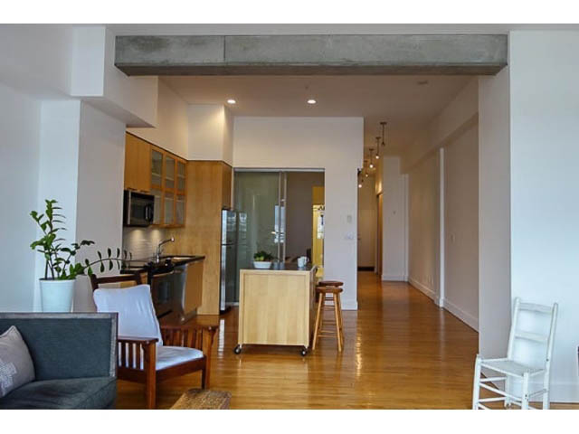Bright kitchen with wooden cabinets, hardwood floors, and a modern open-concept layout. - 207 - 345 Water St, Vancouver Downtown