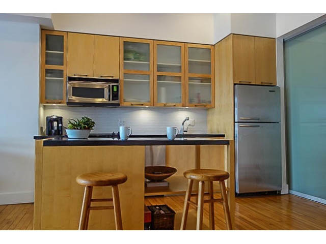 Bright kitchen with wooden cabinets, stainless steel appliances, and hardwood floors. - 207 - 345 Water St, Vancouver Downtown