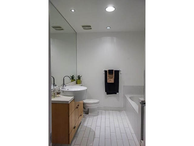 Bright bathroom with white tiles and wooden cabinets. - 207 - 345 Water St, Vancouver Downtown