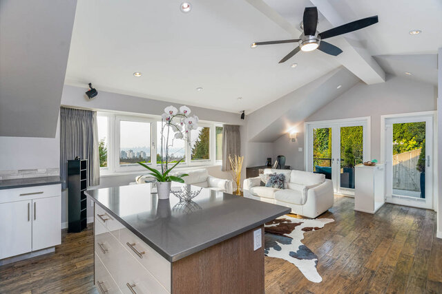 Spacious living room with hardwood floors, cowhide rug, and city view. - 420-B Tempe Crescent, North Vancouver