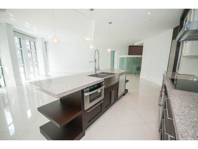 Bright kitchen with granite countertops and modern appliances, showcasing a sleek, contemporary design.