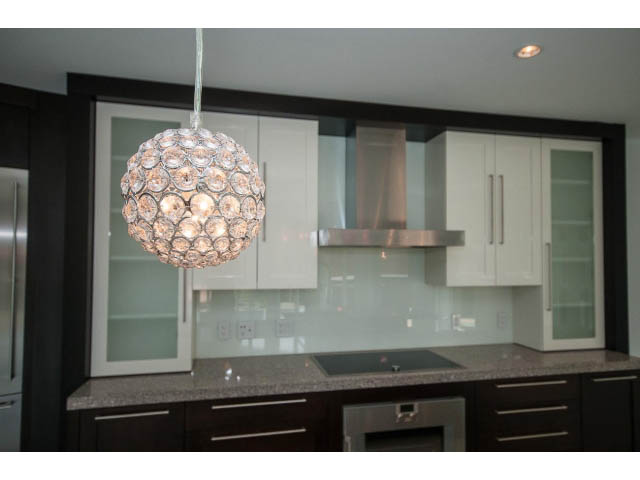 Bright kitchen with granite countertops, modern pendant light, and sleek cabinetry.