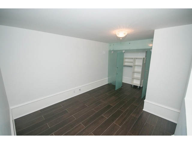 Bright living room with hardwood floors and white walls, featuring a built-in shelving unit.