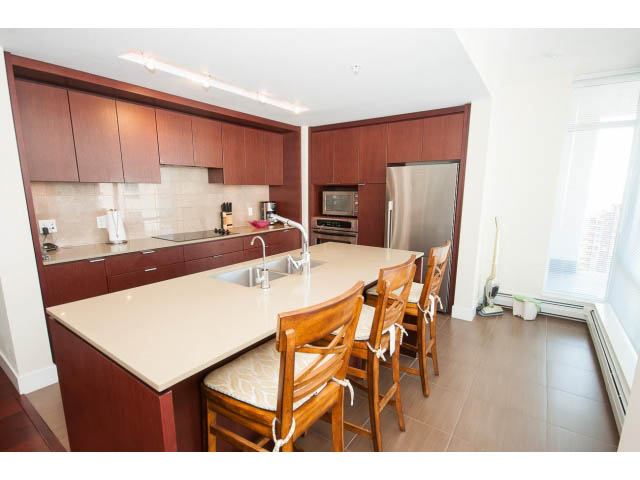 Bright kitchen with modern cabinetry, granite countertops, hardwood floors, and a city view. - 1606-158 West 13th Street, North Vancouver